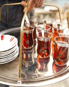 A waiter carrying a tray of Turkish tea